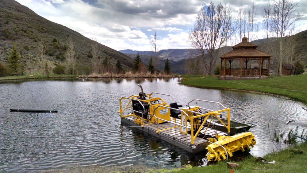 pond cleaning equipment machine on a pond in Colorado surrounded by mountains